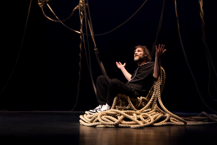Man sitting on a chair with ropes